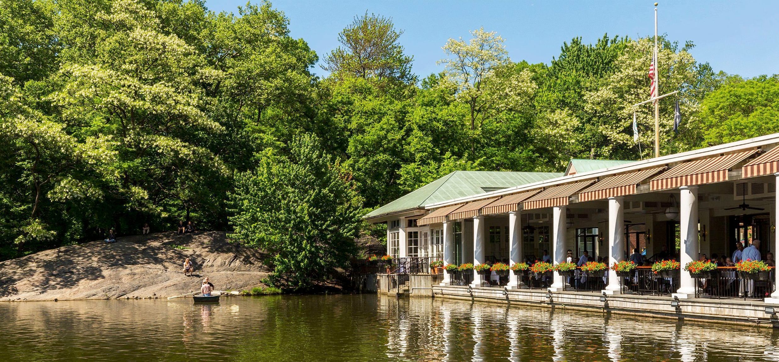 The boathouse is seen reflected in the waters of the Lake.
