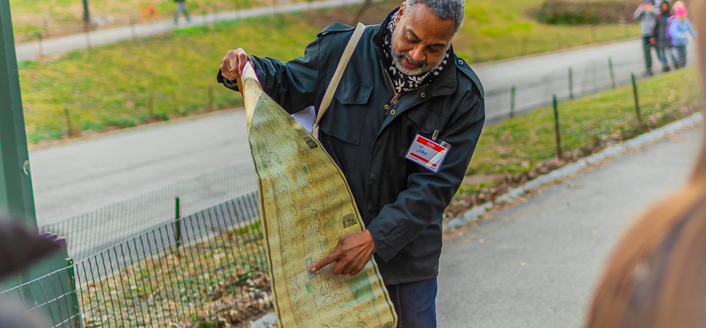 A Central Park Conservancy guide holds a map at Seneca Village in Central Park, NYC